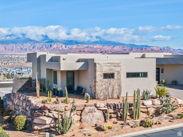 view of front of home featuring a mountain view, a patio, and stucco siding