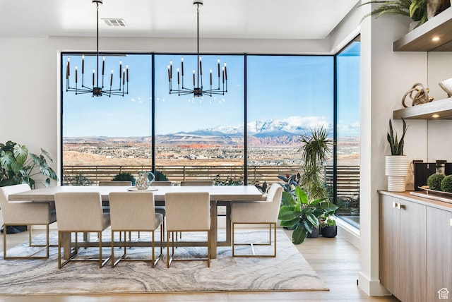 dining area featuring a mountain view, wood finished floors, and visible vents
