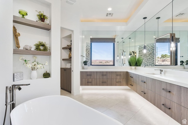full bath with visible vents, built in shelves, a freestanding bath, and vanity