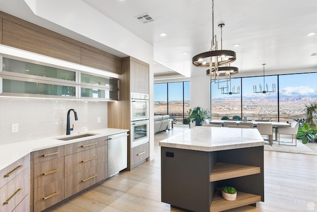 kitchen with visible vents, dishwasher, modern cabinets, and a sink