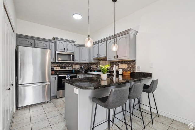 1134 E 3300 S Unit 216, Millcreek, UT 84106 - kitchen with backsplash, gray cabinetry, light tile patterned floors, a peninsula, and stainless steel appliances