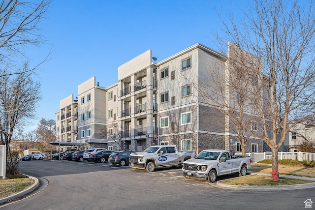 1134 E 3300 S Unit 216, Millcreek, UT 84106 - view of building exterior featuring uncovered parking and fence