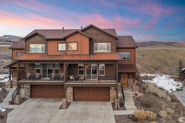 1733 E Viewside Cir, Hideout, UT 84036 - rustic home with stone siding, an attached garage, driveway, a standing seam roof, and a mountain view