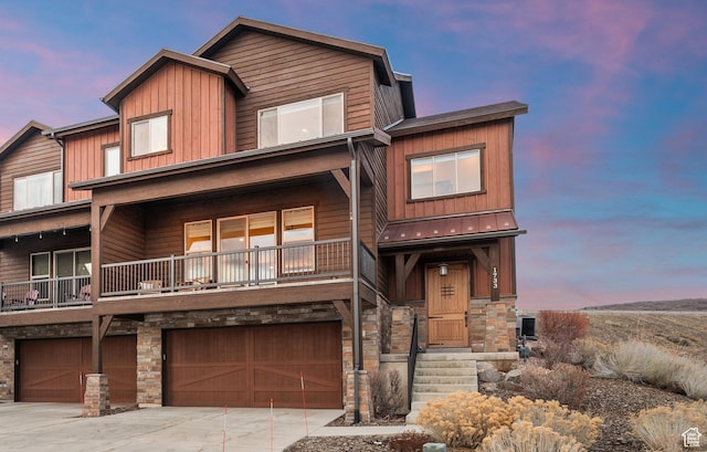 1733 E Viewside Cir, Hideout, UT 84036 - view of front of home with stone siding, board and batten siding, a garage, concrete driveway, and a balcony