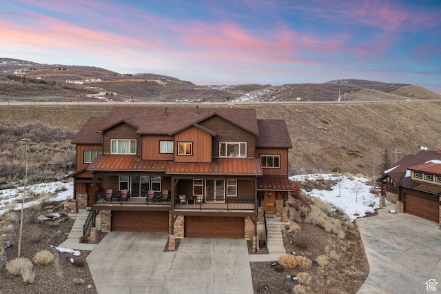 1733 E Viewside Cir, Hideout, UT 84036 - rustic home featuring a garage, driveway, stairs, stone siding, and metal roof