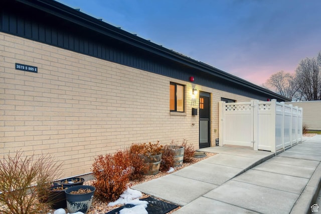 3578 S 805 E Unit 237, Millcreek, UT 84106 - exterior entry at dusk featuring brick siding, fence, and a gate