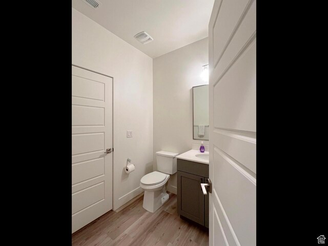 3578 S 805 E Unit 237, Millcreek, UT 84106 - half bathroom featuring vanity, baseboards, toilet, visible vents, and wood finished floors