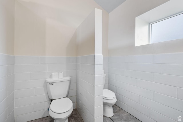 6948 W Dusty Rose Cir, Herriman, UT 84065 - bathroom featuring tile walls, toilet, wood finished floors, and a wainscoted wall