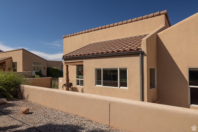 3686 S Spanish Valley Dr Unit U-3, Moab, UT 84532 - rear view of property featuring stucco siding, fence, and a tile roof