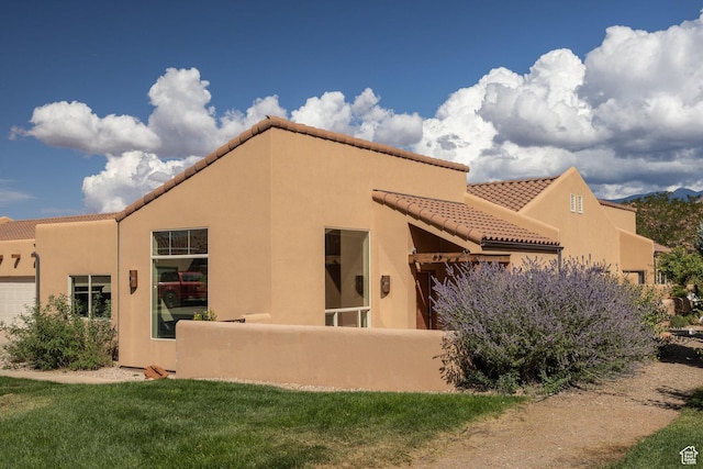 3686 S Spanish Valley Dr Unit U-3, Moab, UT 84532 - back of house with stucco siding, a tiled roof, and a garage