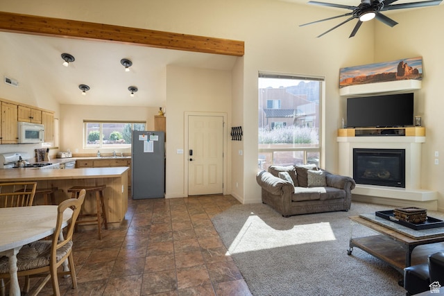 3686 S Spanish Valley Dr Unit U-3, Moab, UT 84532 - living room with visible vents, beam ceiling, high vaulted ceiling, a glass covered fireplace, and ceiling fan