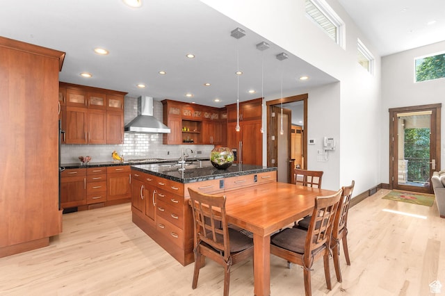4127 E Mathews Way S, Salt Lake City, UT 84124 - kitchen featuring light wood finished floors, stainless steel gas cooktop, recessed lighting, brown cabinets, and wall chimney range hood