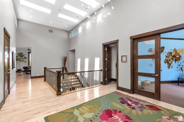 4127 E Mathews Way S, Salt Lake City, UT 84124 - hallway featuring an upstairs landing, a skylight, light wood-style flooring, a high ceiling, and visible vents