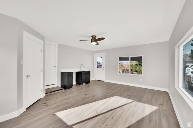 2745 E 3100 S, Millcreek, UT 84109 - unfurnished living room with baseboards, light wood-style floors, and a ceiling fan