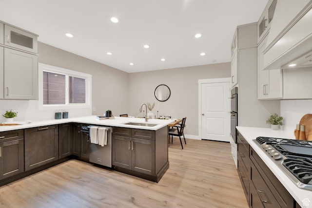 2745 E 3100 S, Millcreek, UT 84109 - kitchen featuring light wood-type flooring, a sink, stainless steel appliances, a peninsula, and custom exhaust hood