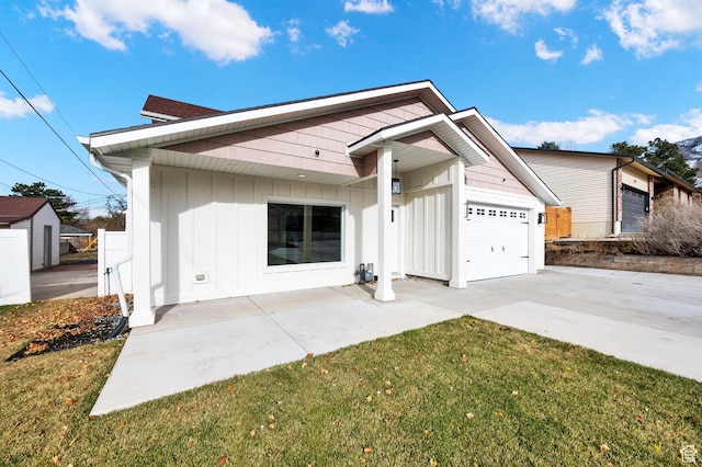 2745 E 3100 S, Millcreek, UT 84109 - view of front of house featuring a front yard, board and batten siding, concrete driveway, and an attached garage