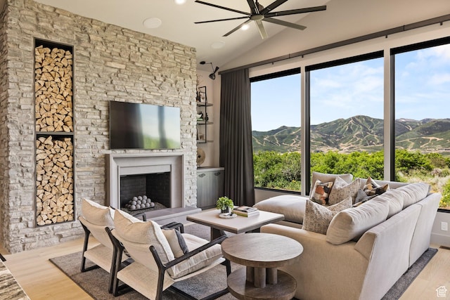 11503 N Soaring Hawk Ln, Hideout, UT 84036 - living room with wood finished floors, a ceiling fan, lofted ceiling, a fireplace with raised hearth, and plenty of natural light