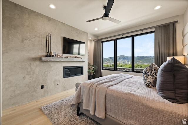 11503 N Soaring Hawk Ln, Hideout, UT 84036 - bedroom with wood finished floors, a glass covered fireplace, recessed lighting, and a ceiling fan