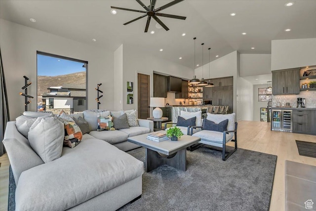 11503 N Soaring Hawk Ln, Hideout, UT 84036 - living area with wine cooler, a ceiling fan, recessed lighting, light wood-style floors, and high vaulted ceiling