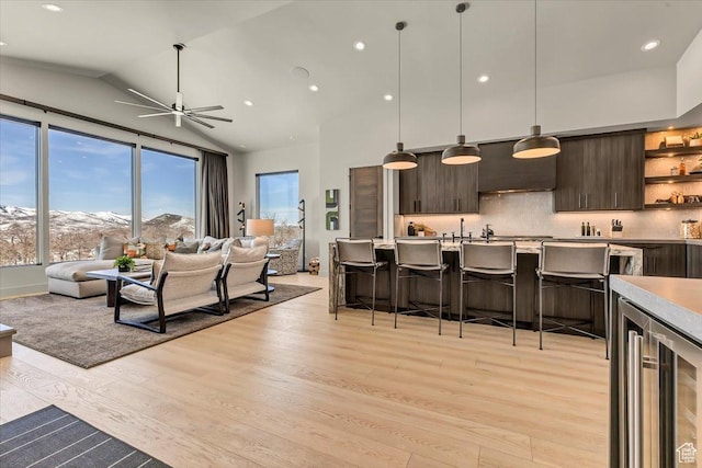 11503 N Soaring Hawk Ln, Hideout, UT 84036 - living room featuring wine cooler, light wood-type flooring, a ceiling fan, recessed lighting, and high vaulted ceiling