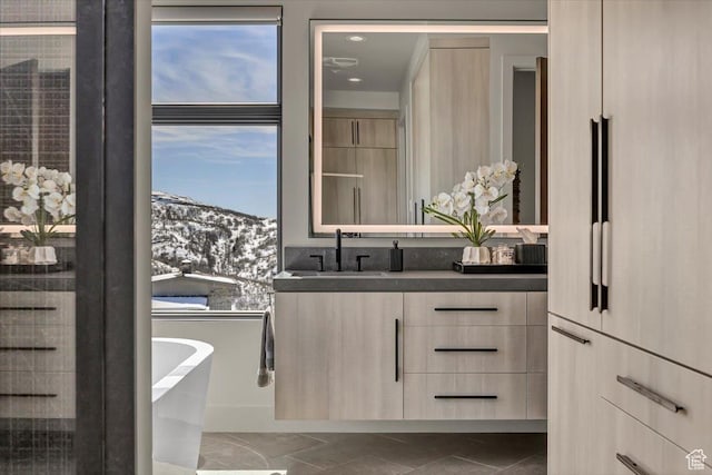 11503 N Soaring Hawk Ln, Hideout, UT 84036 - bathroom with double vanity, a mountain view, a freestanding bath, and tile patterned floors