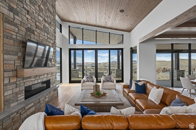 6421 E Evening Star Dr, Kamas, UT 84036 - living area with baseboards, wood ceiling, a stone fireplace, wood finished floors, and high vaulted ceiling