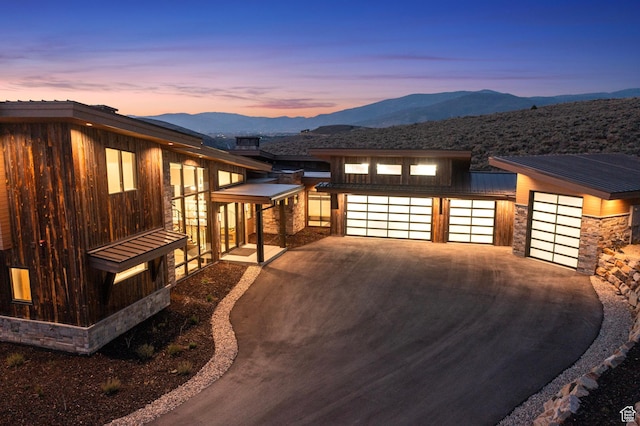 6421 E Evening Star Dr, Kamas, UT 84036 - property exterior at dusk featuring stone siding, a mountain view, and concrete driveway