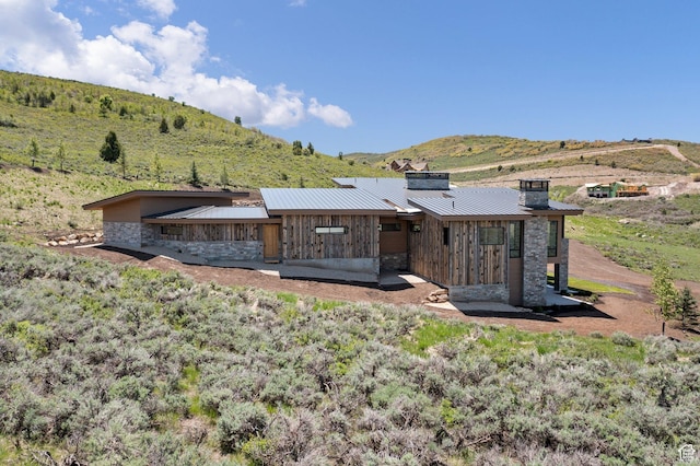 6421 E Evening Star Dr, Kamas, UT 84036 - back of property featuring a chimney, metal roof, stone siding, a mountain view, and a standing seam roof