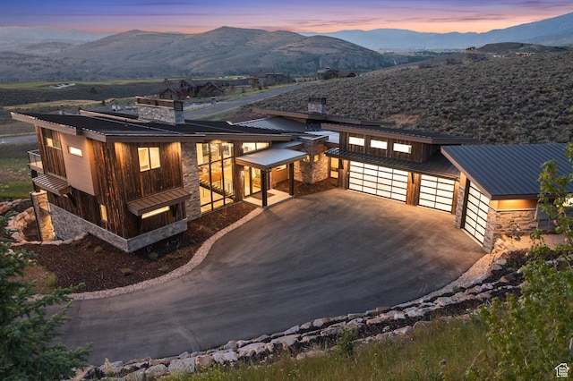 view of front of property with a mountain view, stone siding, and metal roof