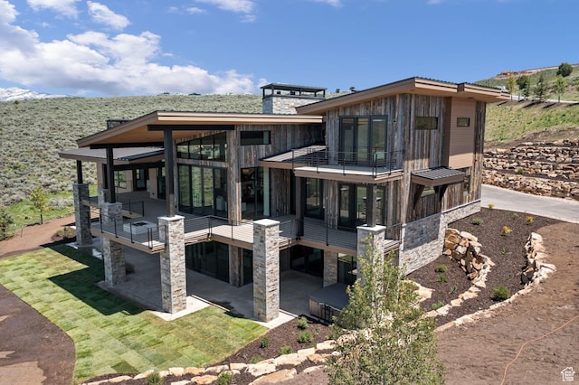 6421 E Evening Star Dr, Kamas, UT 84036 - back of property featuring a patio area, stone siding, a sunroom, and a chimney