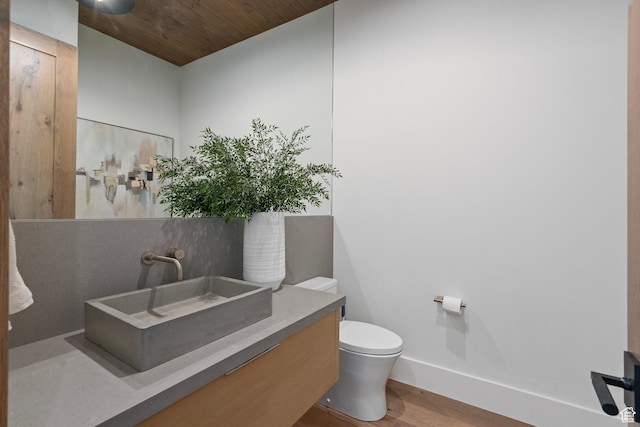 6421 E Evening Star Dr, Kamas, UT 84036 - half bathroom with baseboards, wood ceiling, toilet, wood finished floors, and vanity