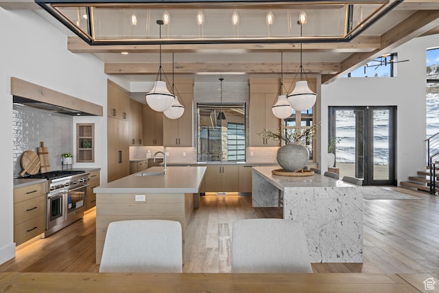 6421 E Evening Star Dr, Kamas, UT 84036 - kitchen with a sink, light countertops, range with two ovens, a high ceiling, and a kitchen island with sink