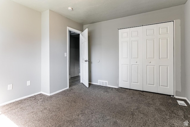 1325 S Lincoln Ave Unit 19, Ogden, UT 84404 - unfurnished bedroom with a closet, baseboards, visible vents, and dark carpet