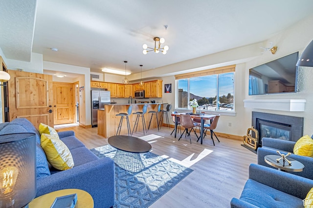 2669 Canyons Resort Dr Unit 314, Park City, UT 84098 - living room featuring a glass covered fireplace, baseboards, light wood finished floors, and a chandelier
