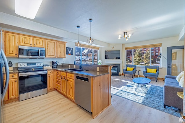 2669 Canyons Resort Dr Unit 314, Park City, UT 84098 - kitchen featuring a sink, open floor plan, stainless steel appliances, light wood-style floors, and a peninsula