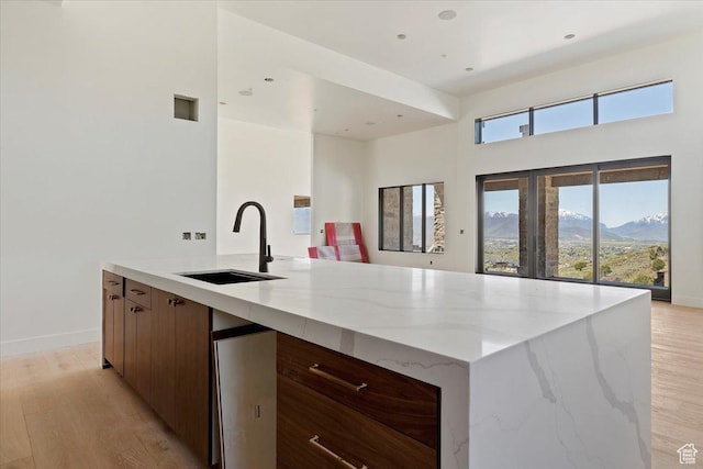 1878 E Chimney Rock Rd S Unit 536, Heber City, UT 84032 - kitchen featuring a sink, modern cabinets, light wood-style flooring, light stone countertops, and a towering ceiling
