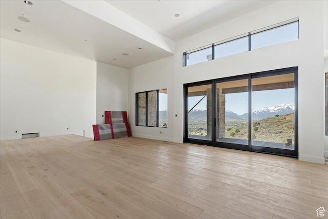 1878 E Chimney Rock Rd S Unit 536, Heber City, UT 84032 - unfurnished living room with a high ceiling, light wood-style flooring, baseboards, and a mountain view