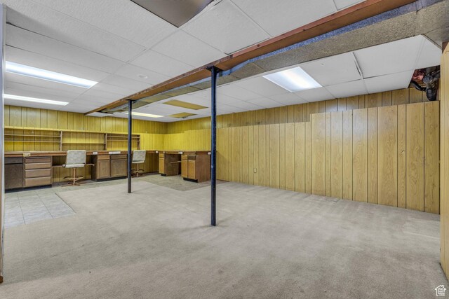 finished basement featuring wooden walls and carpet
