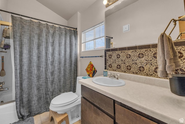 bathroom featuring tile patterned flooring, toilet, vaulted ceiling, shower / tub combo, and vanity