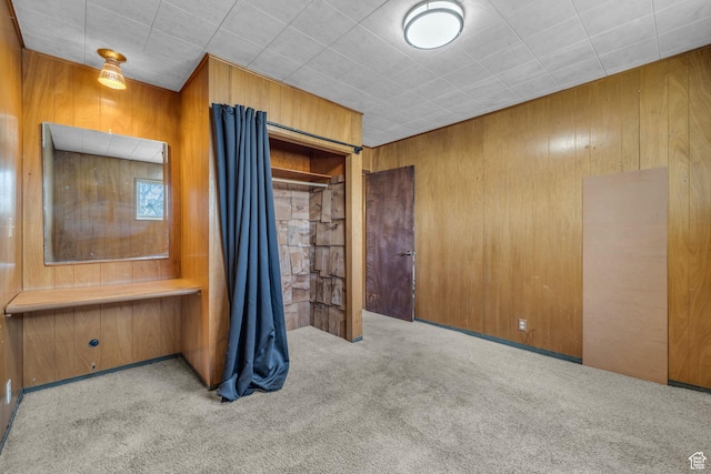 unfurnished bedroom with wooden walls and carpet