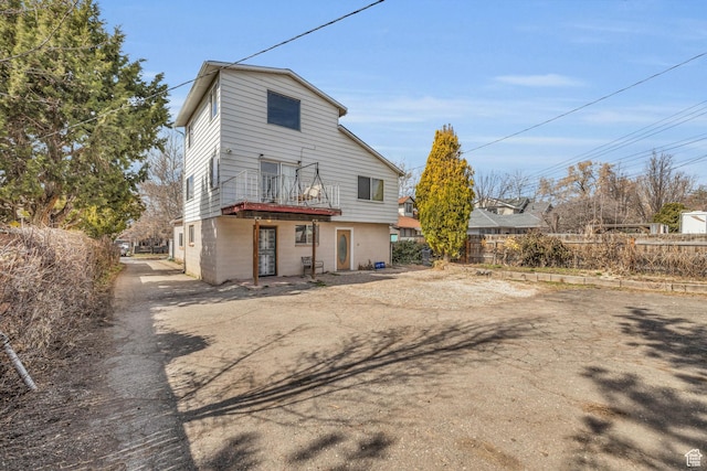 rear view of house featuring fence