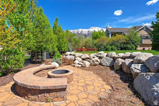 view of patio featuring a fire pit, fence, and a mountain view