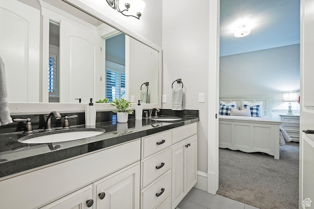 bathroom with ensuite bathroom, tile patterned floors, and double vanity
