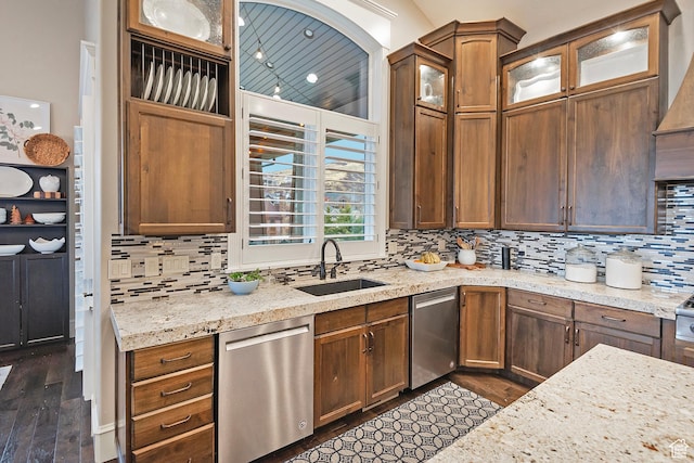kitchen with dishwasher, a sink, dark wood finished floors, tasteful backsplash, and light stone countertops