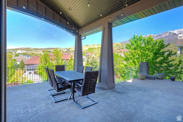 view of patio featuring a mountain view, outdoor dining space, and a balcony