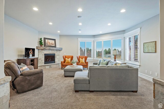 carpeted living room with recessed lighting and a stone fireplace