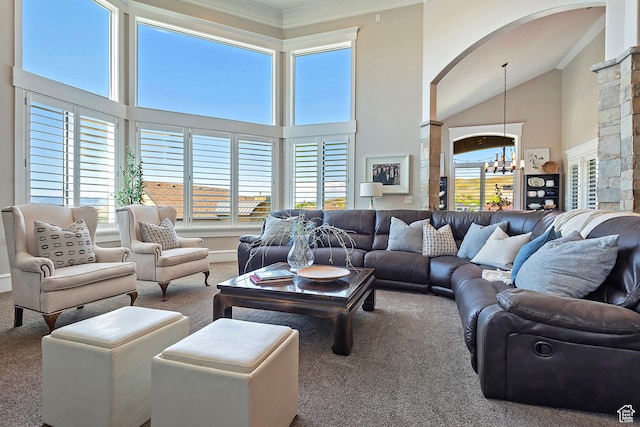 carpeted living area featuring a chandelier, arched walkways, crown molding, and high vaulted ceiling