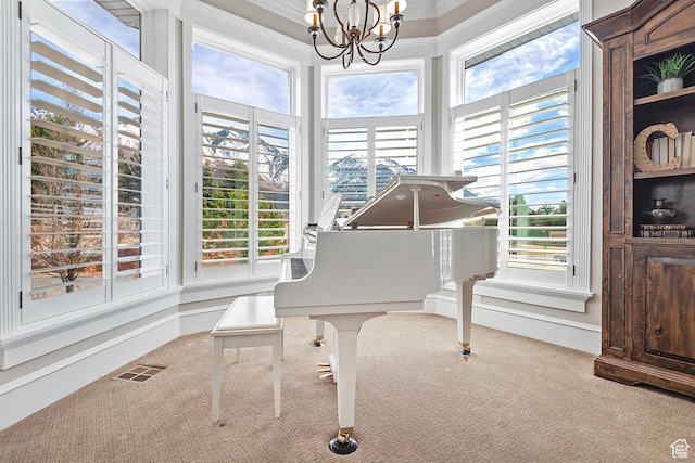 living area featuring carpet floors, plenty of natural light, a chandelier, and ornamental molding