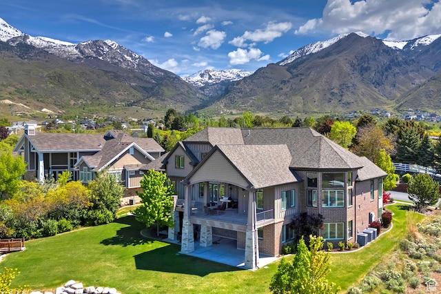 rear view of house featuring a patio area, a yard, cooling unit, and a mountain view