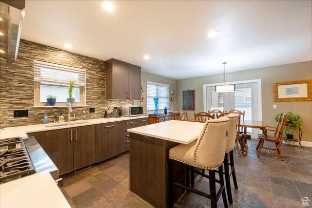 1689 E Kierstin Pl, Salt Lake City, UT 84108 - kitchen featuring stainless steel microwave, a kitchen breakfast bar, light countertops, and a sink